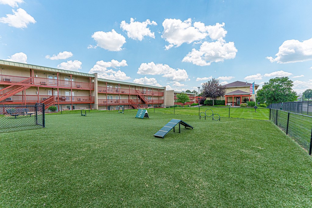 an exterior view of a dog park in front of an apartment building
