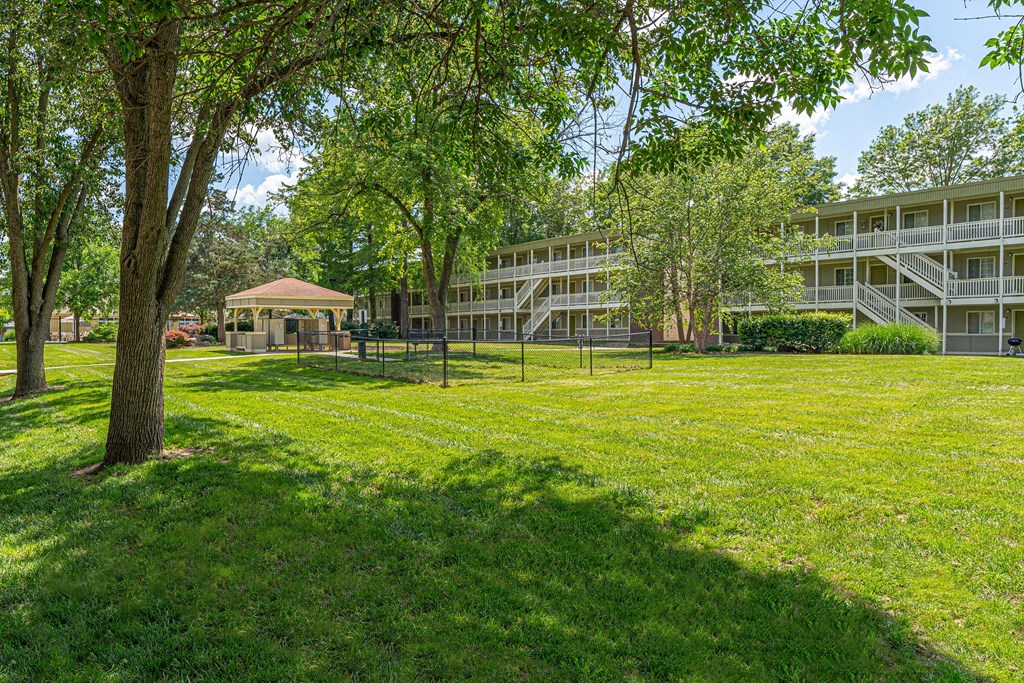 a park with a gazebo in front of an apartment building