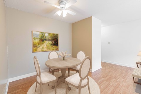 a dining room with a table and chairs and a ceiling fan