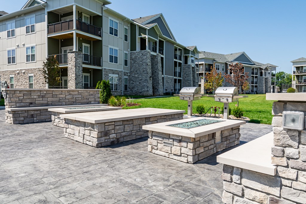 an outdoor patio with a firepit and seating area