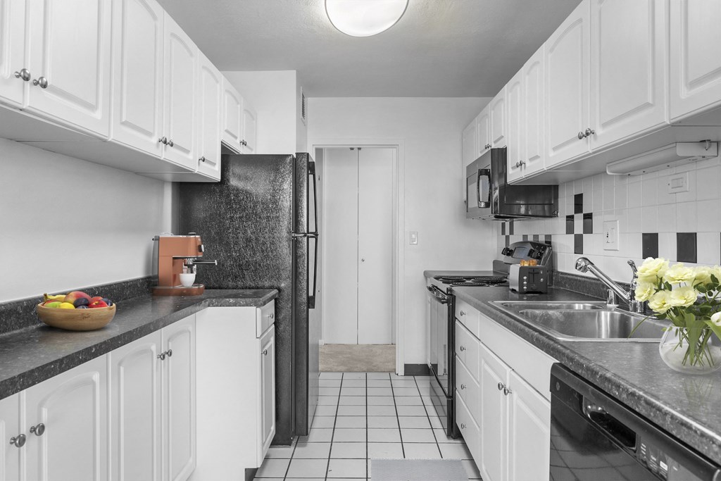 a kitchen with white cabinets and a stainless steel refrigerator