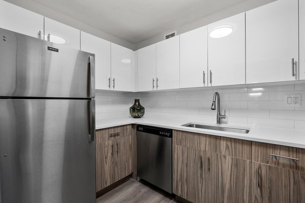 a kitchen with white cabinets and a stainless steel dishwasher