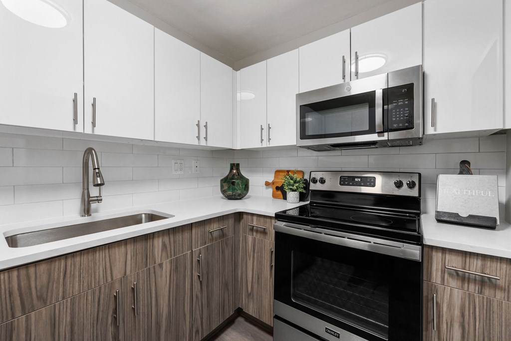 a kitchen with white cabinets and black appliances