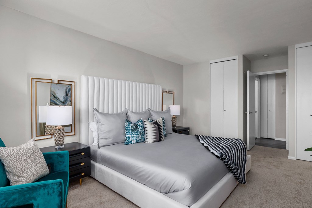 a bedroom with a bed and a chair in a room