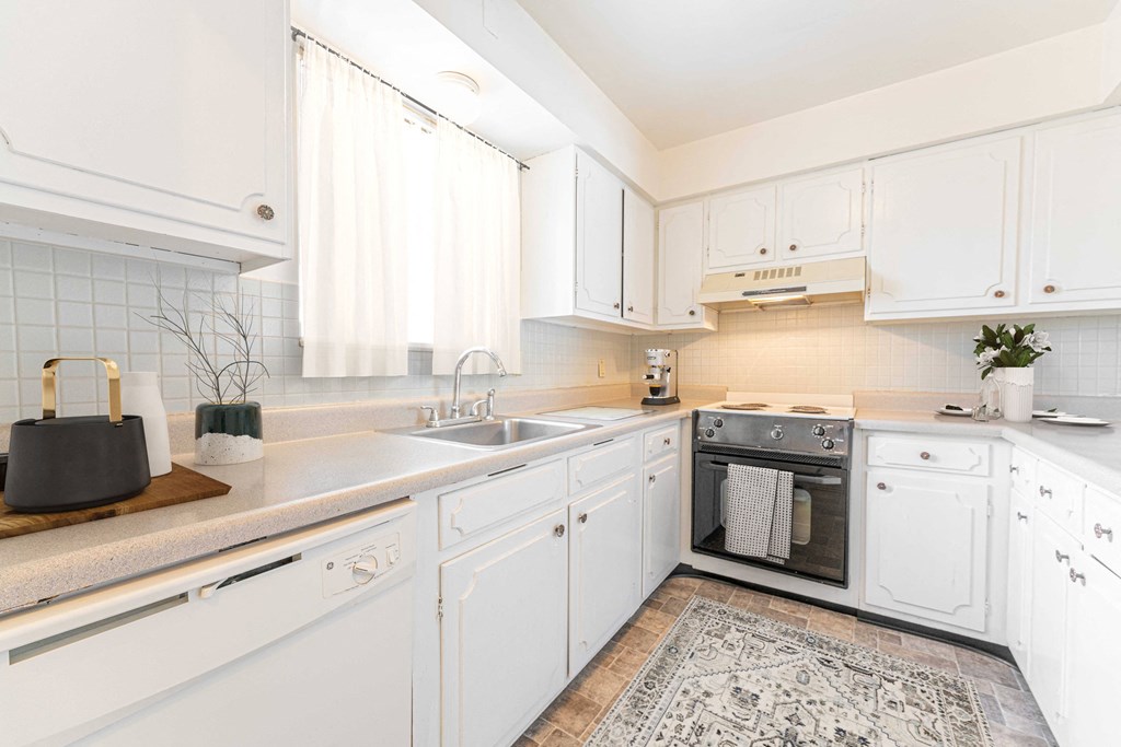 a small kitchen with white cabinets and a sink