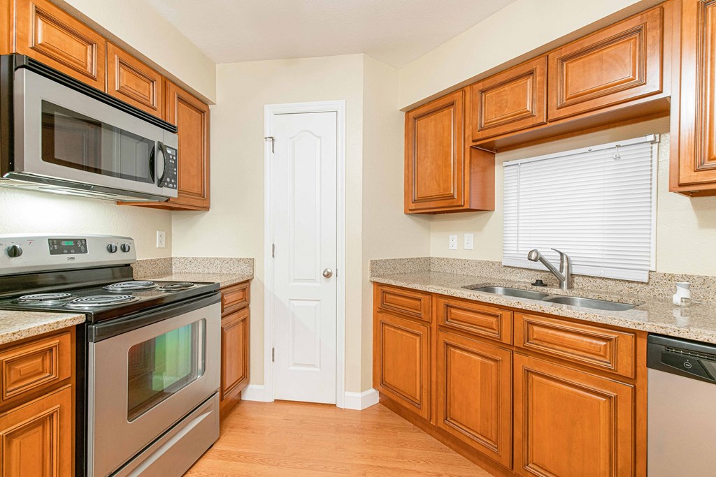 a kitchen with stainless steel appliances and wooden cabinets