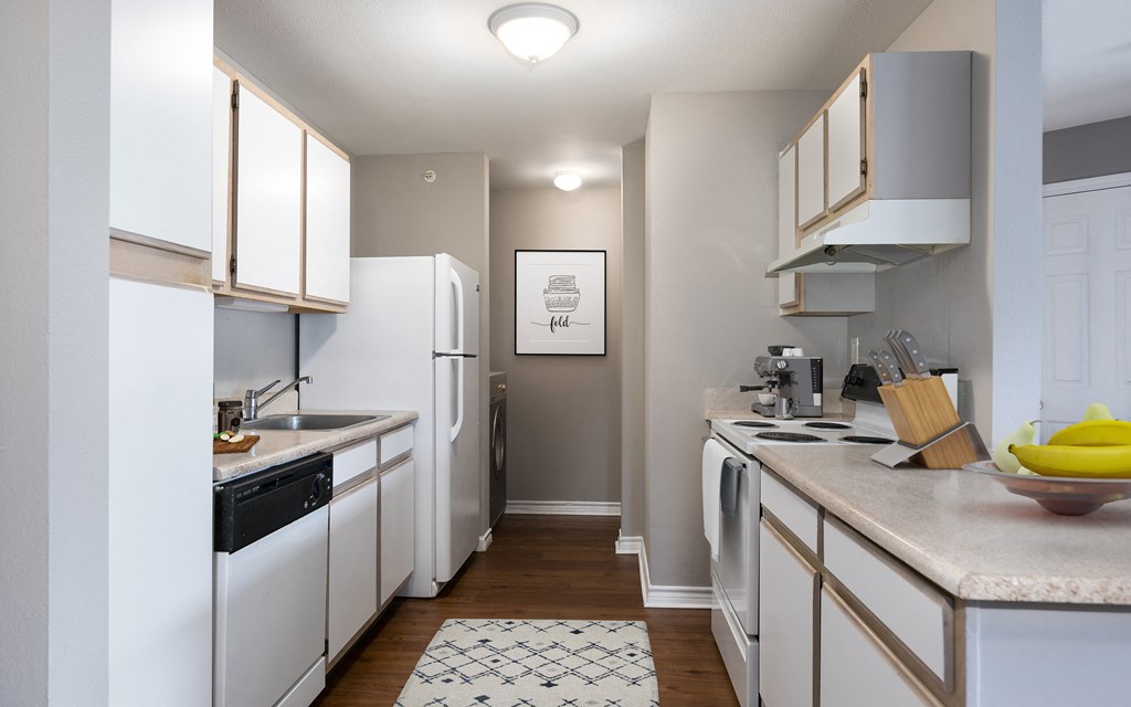 a kitchen with white appliances and counters and a white refrigerator