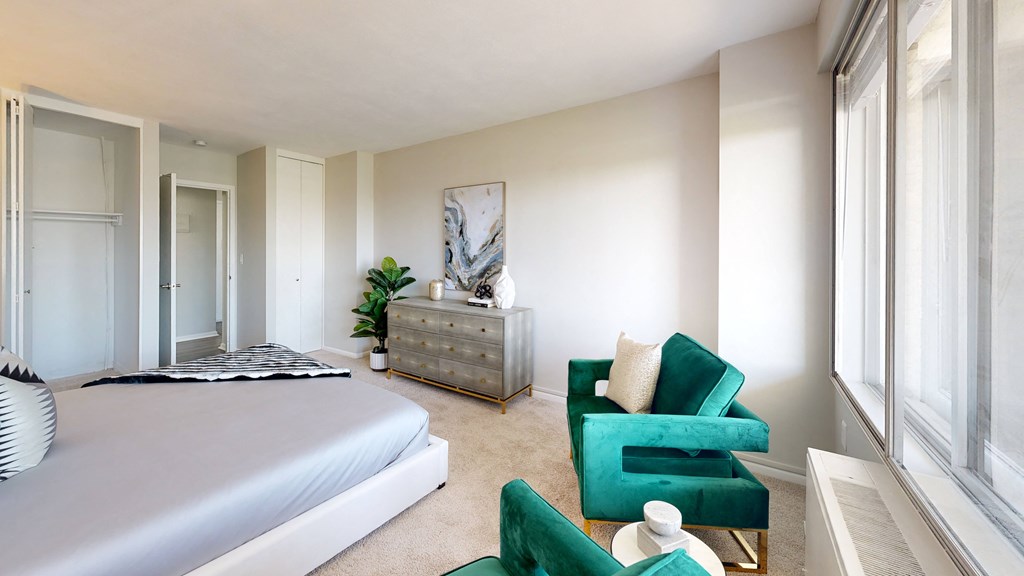 a bedroom with a bed and a dresser in front of a window