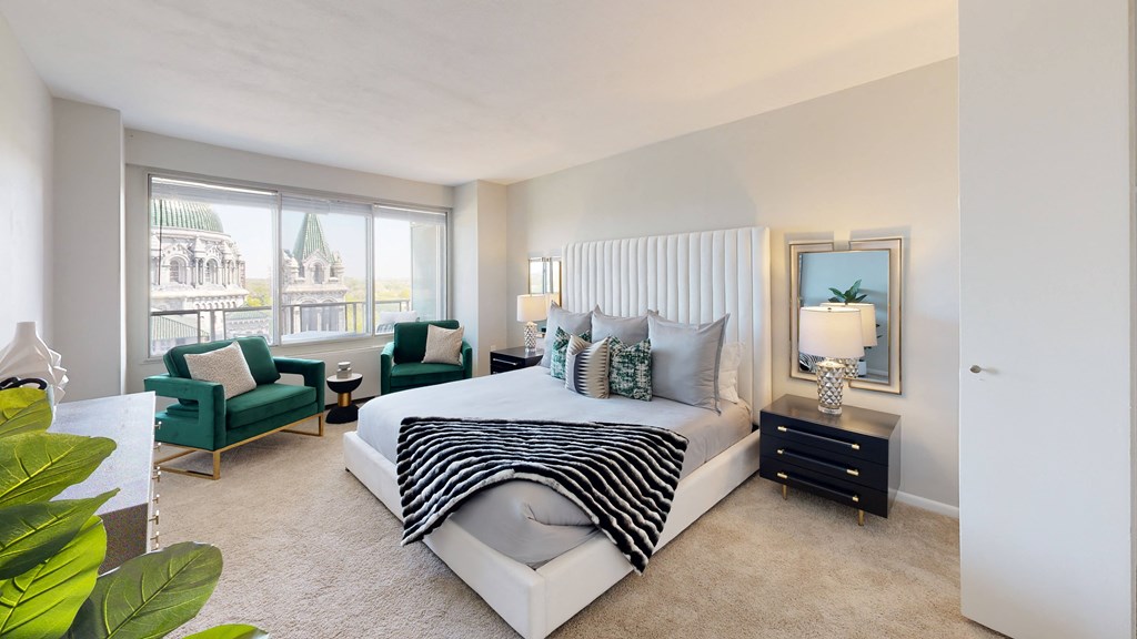 a bedroom with a bed and a chair in front of a window