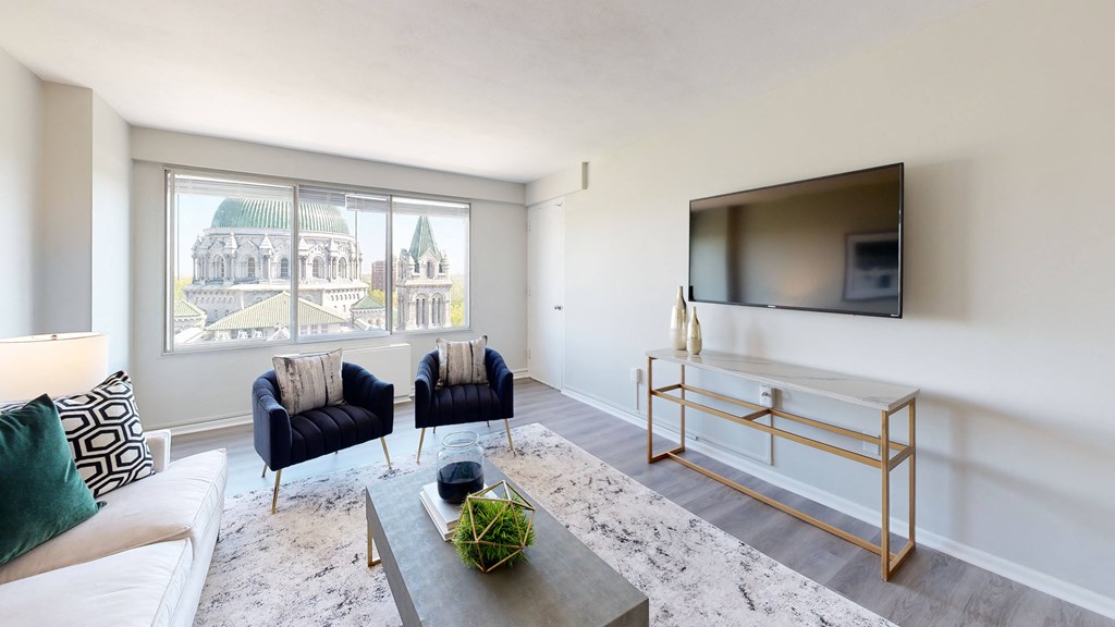 a living room with a large window and a tv on the wall