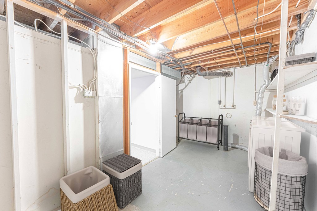 a basement bathroom with a shower and a bed in it