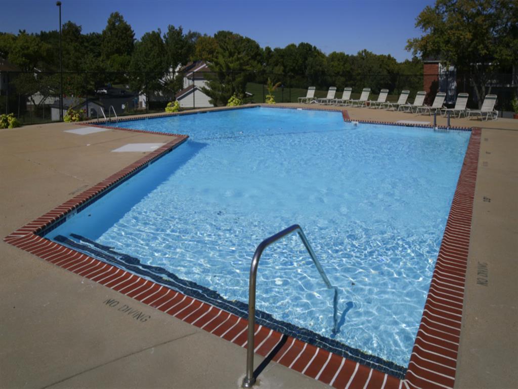 a swimming pool at a resort with chairs around it