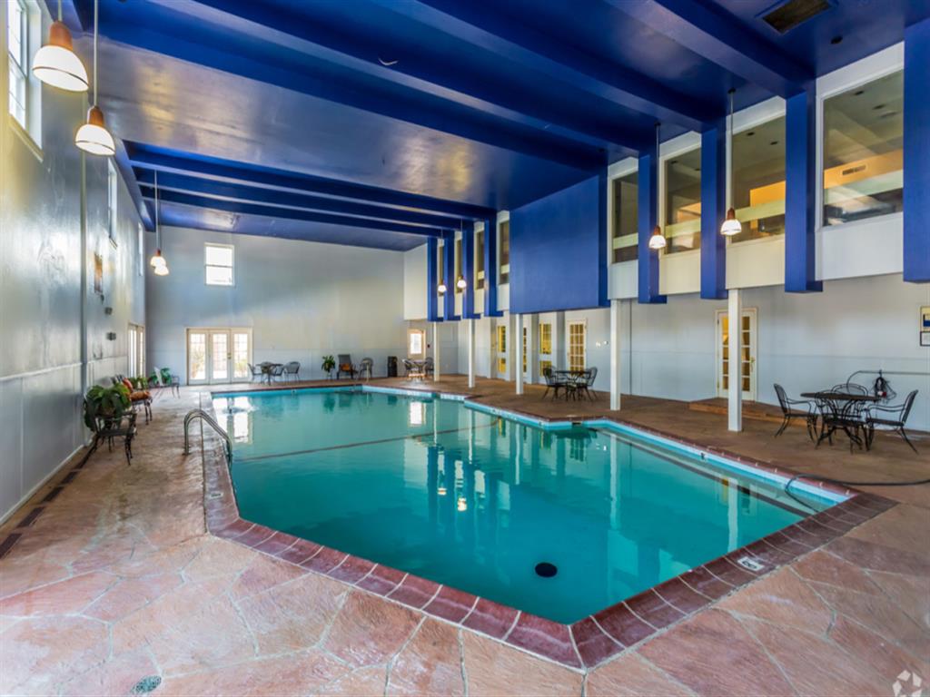 a swimming pool in the lobby of a hotel with a blue ceiling