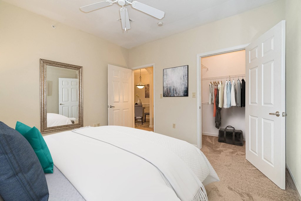 a bedroom with a large white bed and a closet