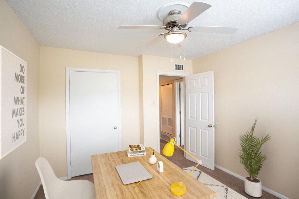 an empty dining room with a table and a ceiling fan