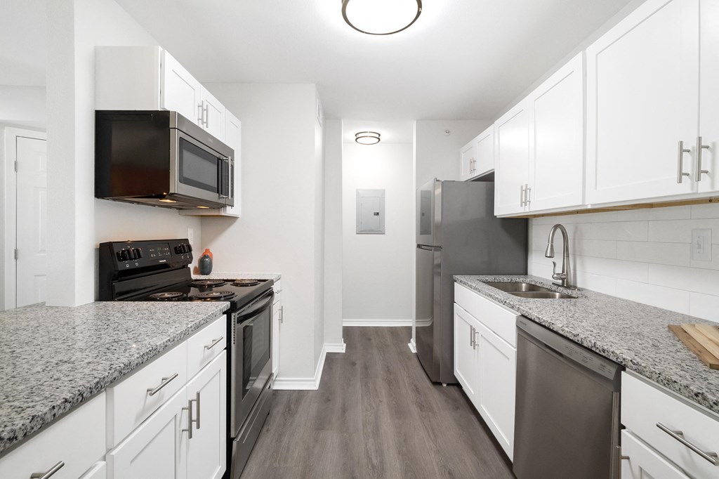 a kitchen with white cabinets and stainless steel appliances and granite counter tops
