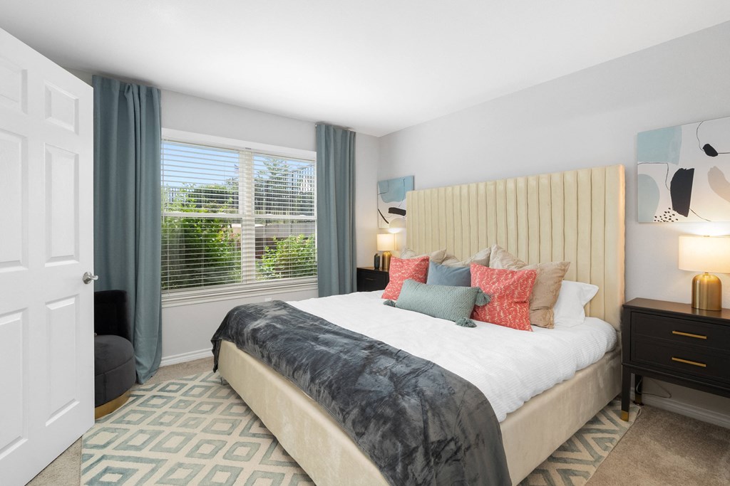 a bedroom with a bed and a large window