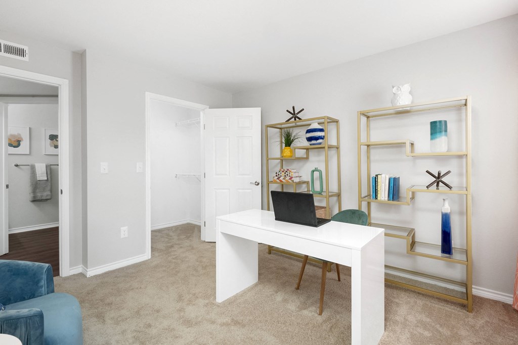 a living room with a white desk with a laptop on it