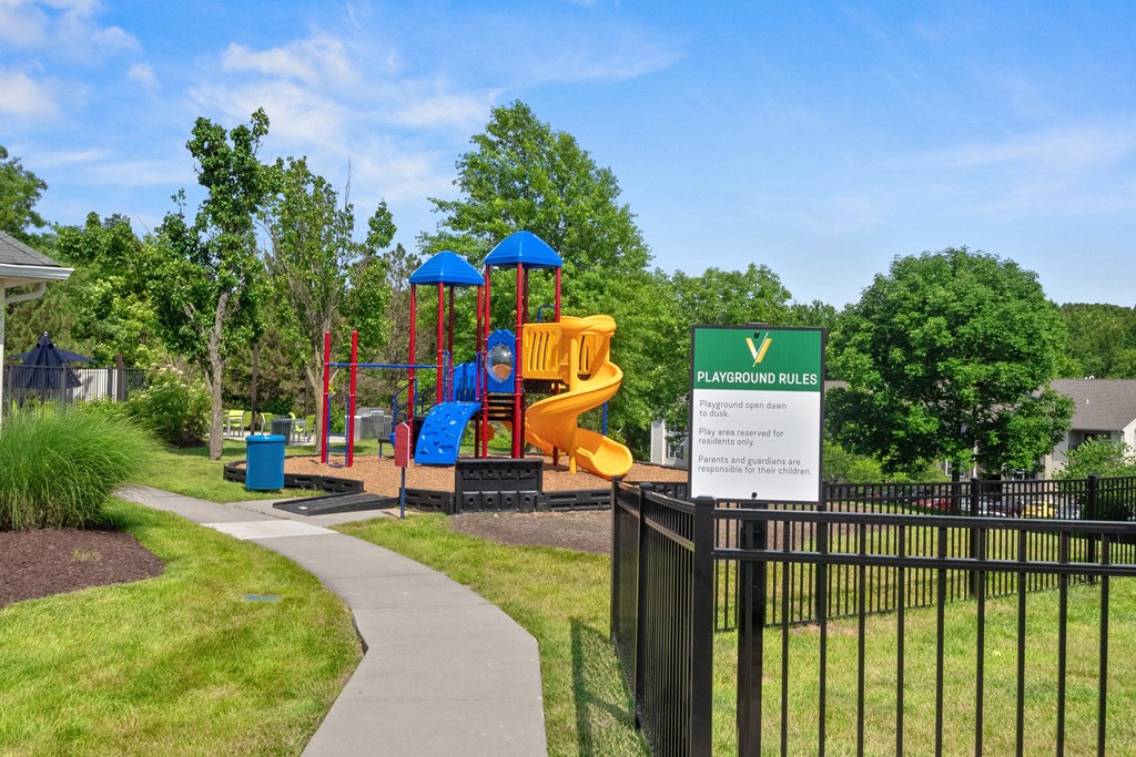 a playground in a park with a sign for a childrens play area