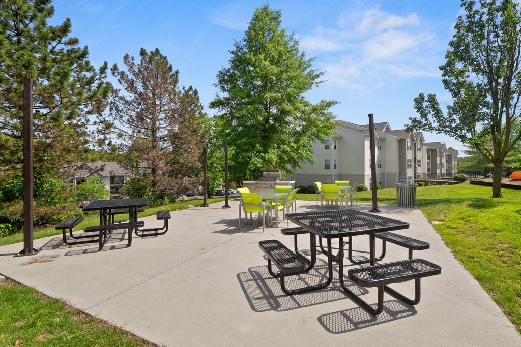 an outdoor patio with tables and chairs and buildings in the background