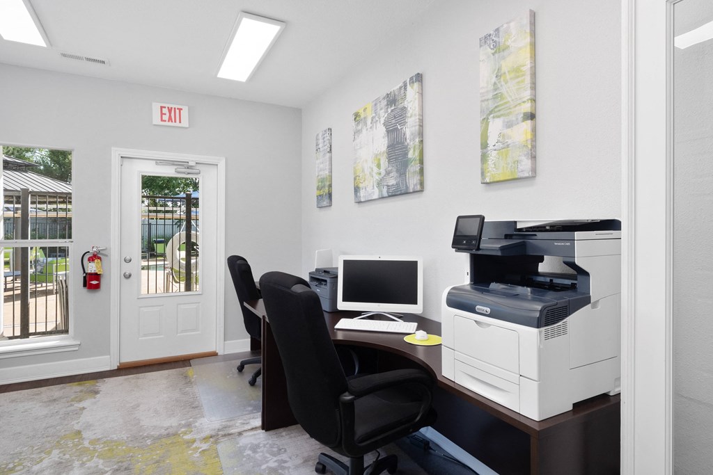an office with a computer and printer and a desk with a monitor and a printer