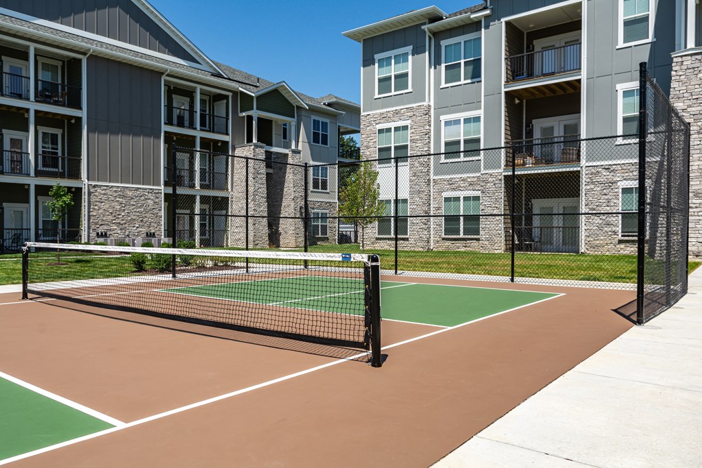 a tennis court at the whispering winds apartments in pearland, tx