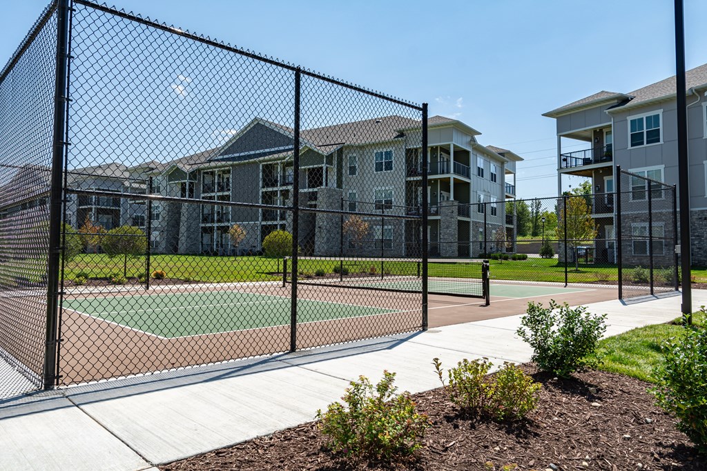 a tennis court at the whispering winds apartments in pearland, tx