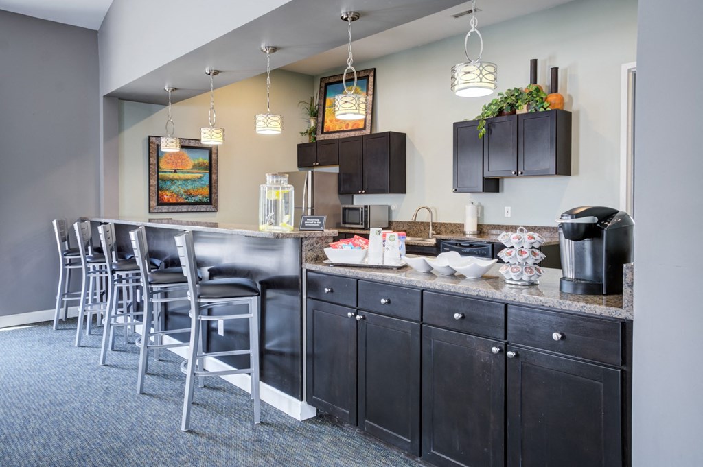 a kitchen with bar stools and a counter with chairs
