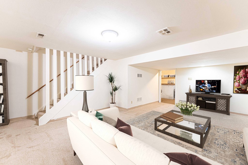 a living room with a white couch and a television