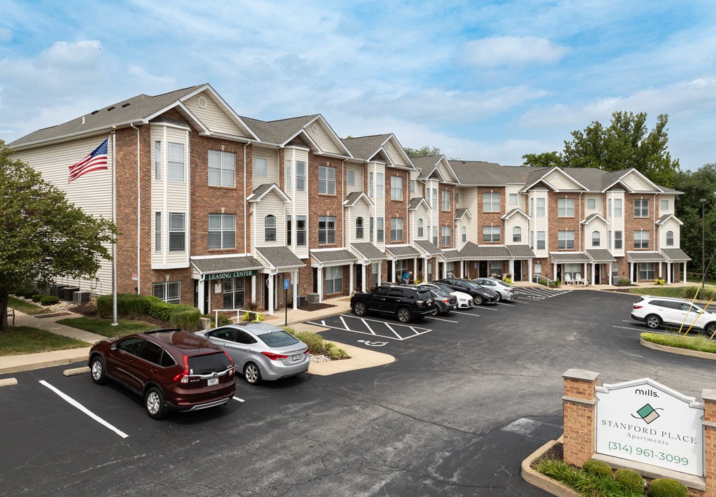 an apartment building with cars parked in front of it