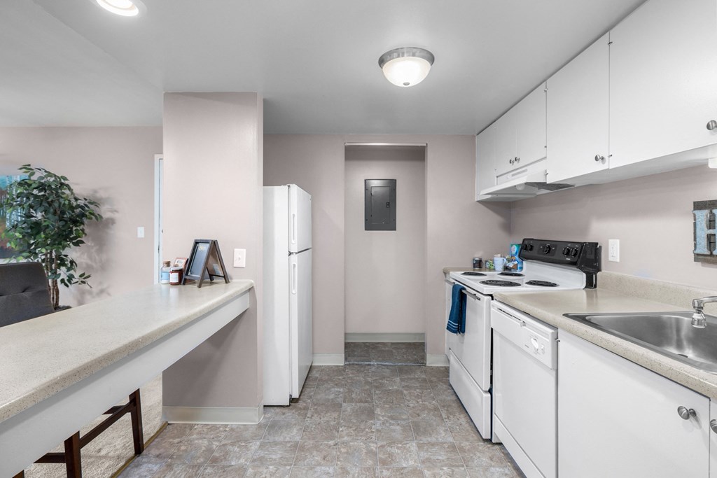 a kitchen with white appliances and counters and white cabinets