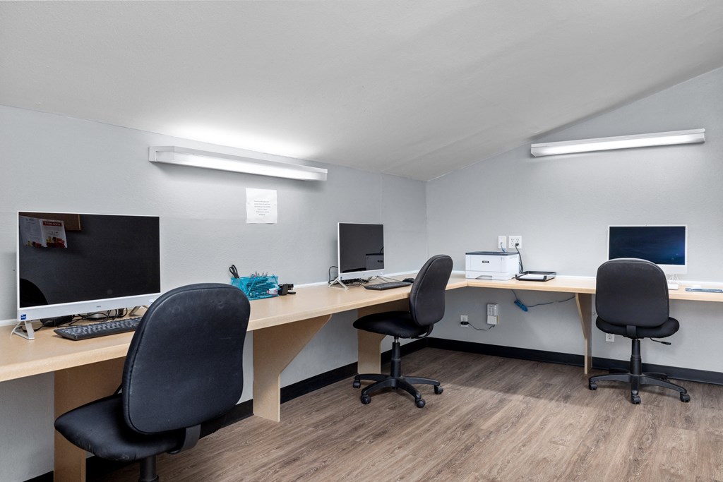 two computers and two chairs in an office