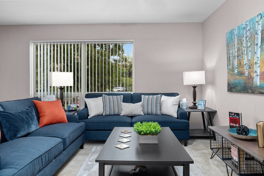 a living room with blue couches and a coffee table