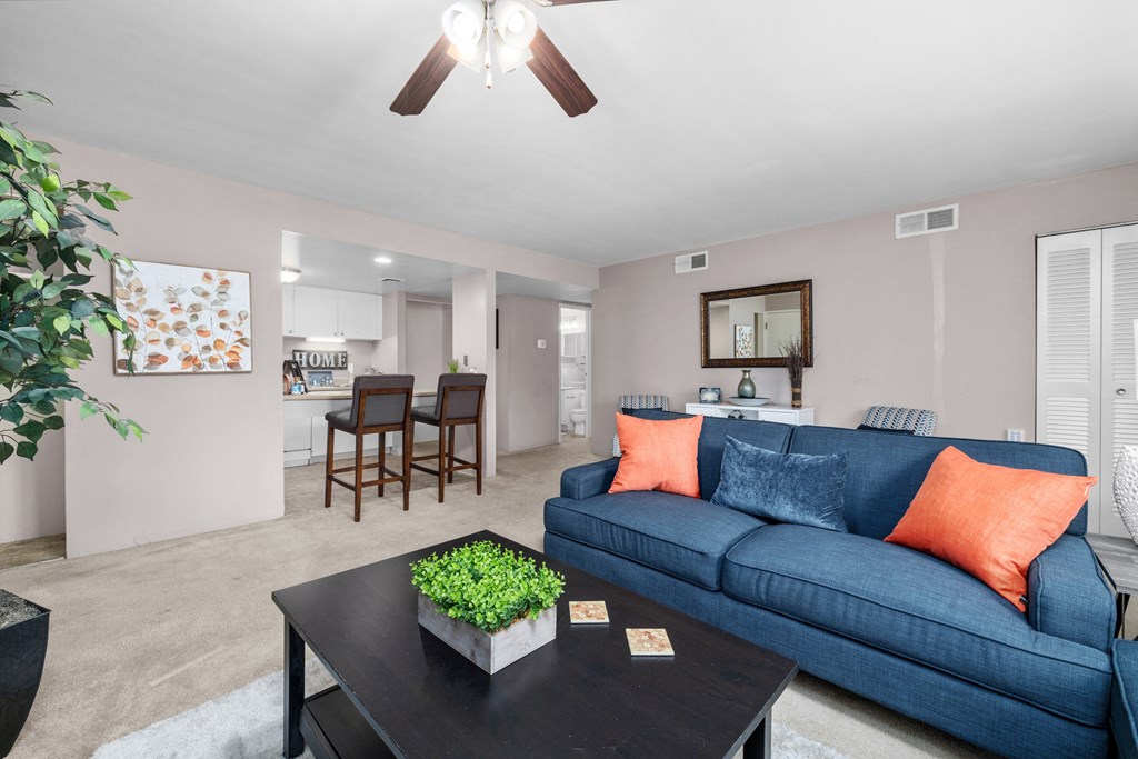 a living room with a blue couch and a coffee table with a plant on top of it