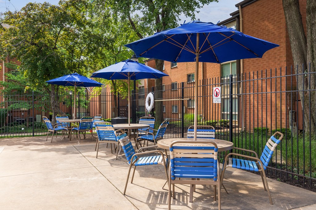 a patio with tables and chairs and umbrellas