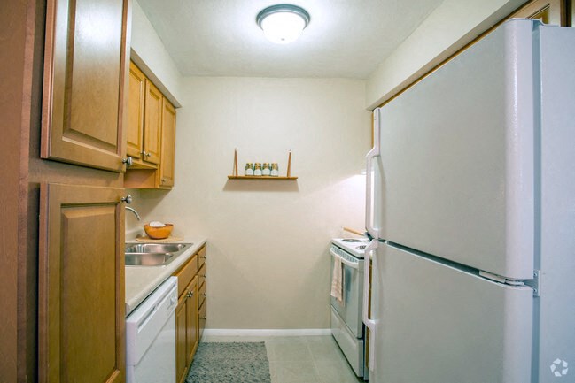 a kitchen with white appliances and wooden cabinets and a refrigerator