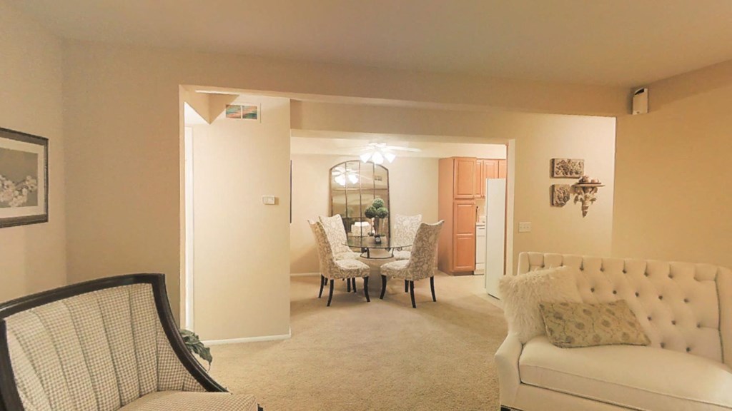 a living room and dining room with a table and chairs