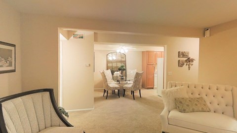 a living room and dining room with a table and chairs