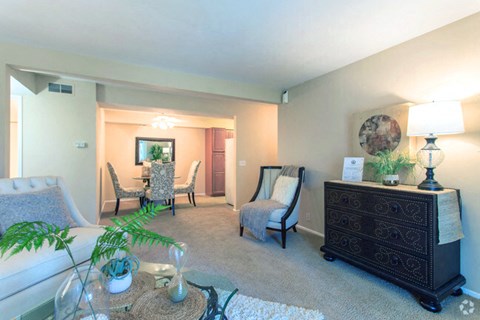 a living room with a couch and chairs and a dining room table
