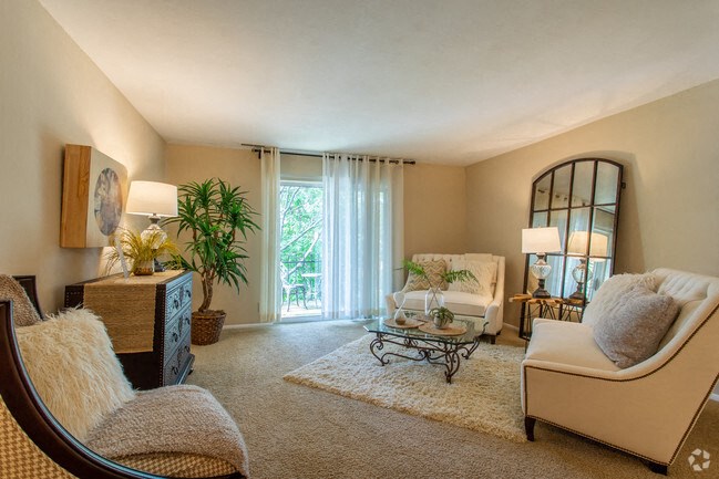 a living room with a couch and a chair and a mirror