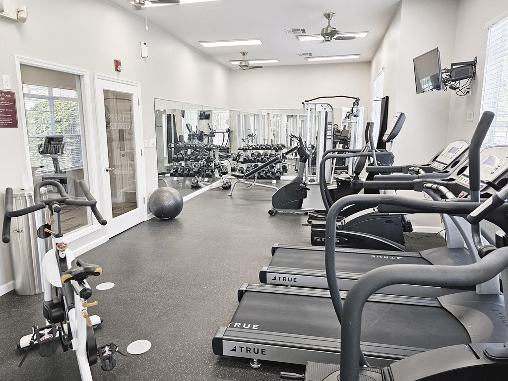 a gym with cardio equipment and weights