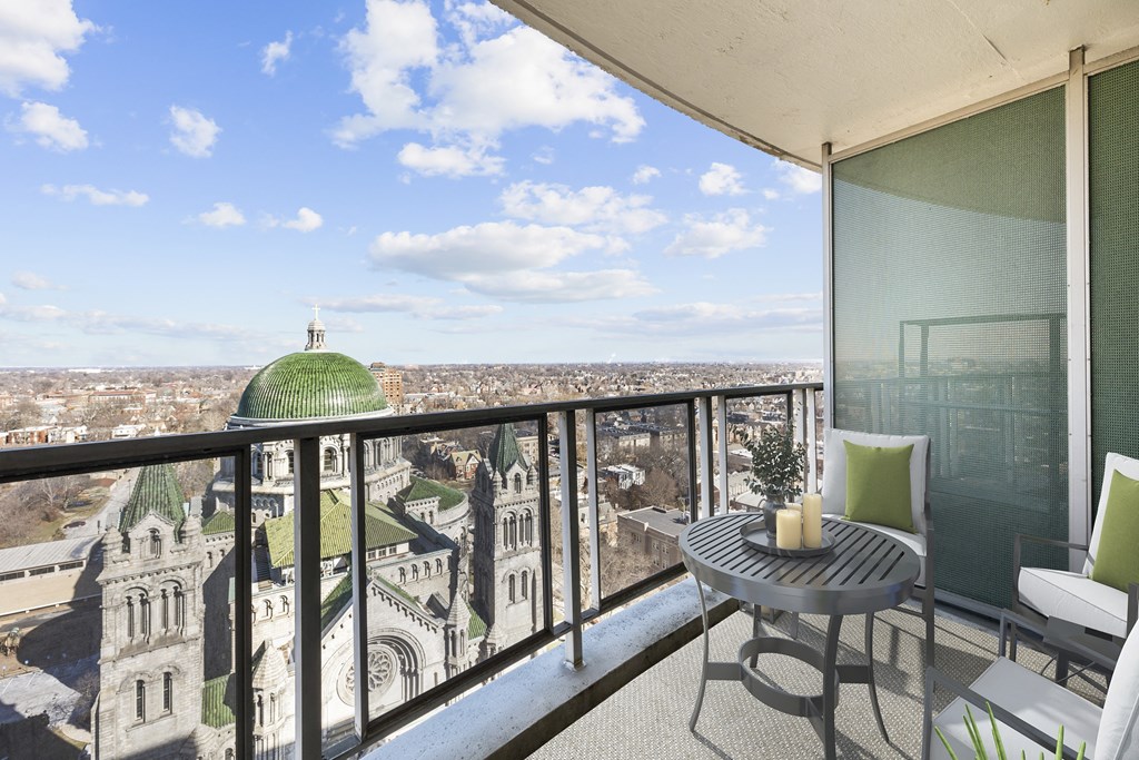 a balcony with a view of a mosque and a table and chairs