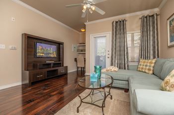 A living room with a television, a couch, and a coffee table.
