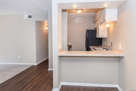 A kitchen area with a sink and a refrigerator.