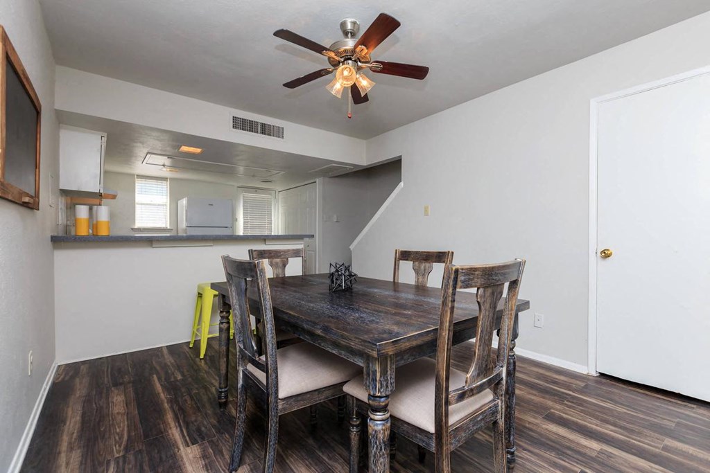 a dining room with a table and chairs and a ceiling fan