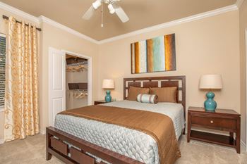 A bedroom with a large bed and a ceiling fan.