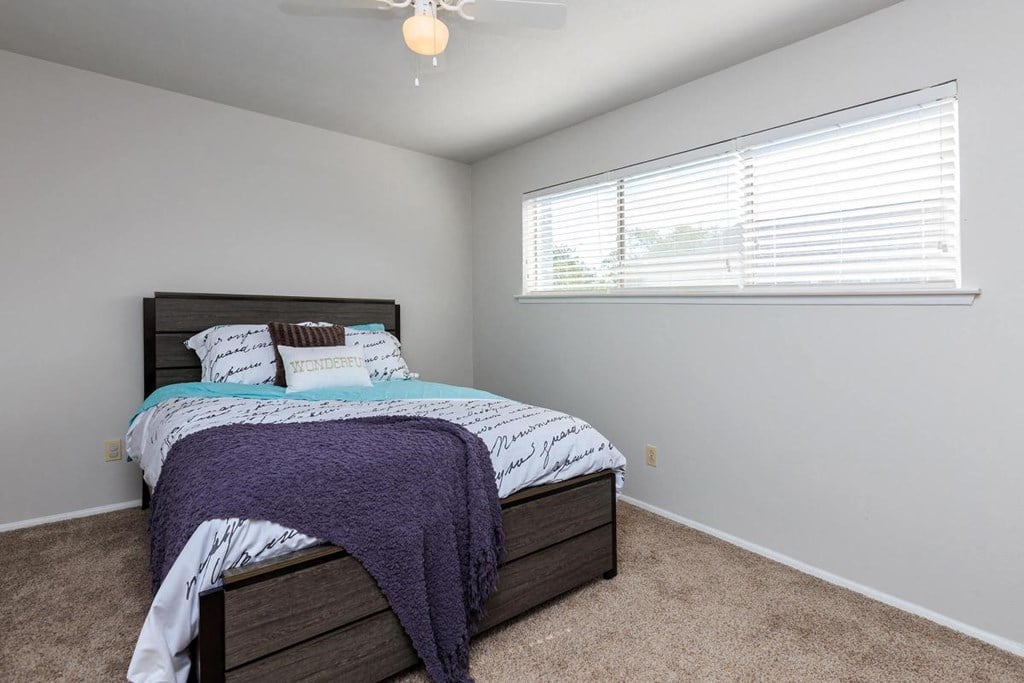 a bedroom with a bed and a large window
