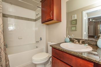 A bathroom with a white toilet and a brown cabinet.