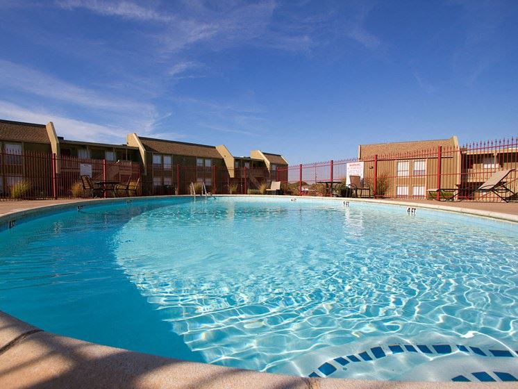 a large swimming pool with apartments in the background