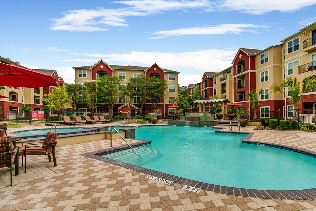 a swimming pool with an apartment building in the background